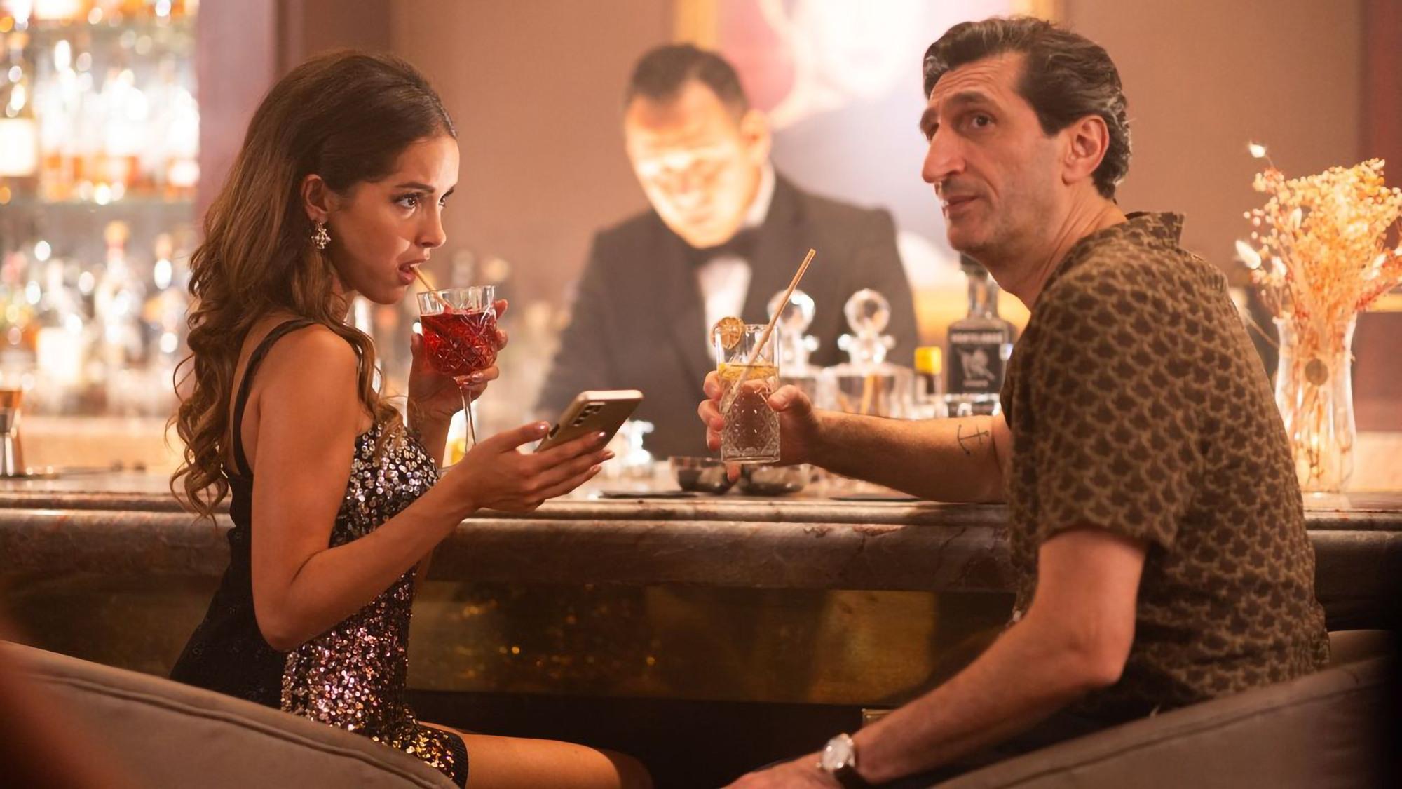 A woman and a man at a bar, and a bartender behind the bar. Still picture from 'Eagles of the Republic', a 2025 addition to Swedish films and series. 