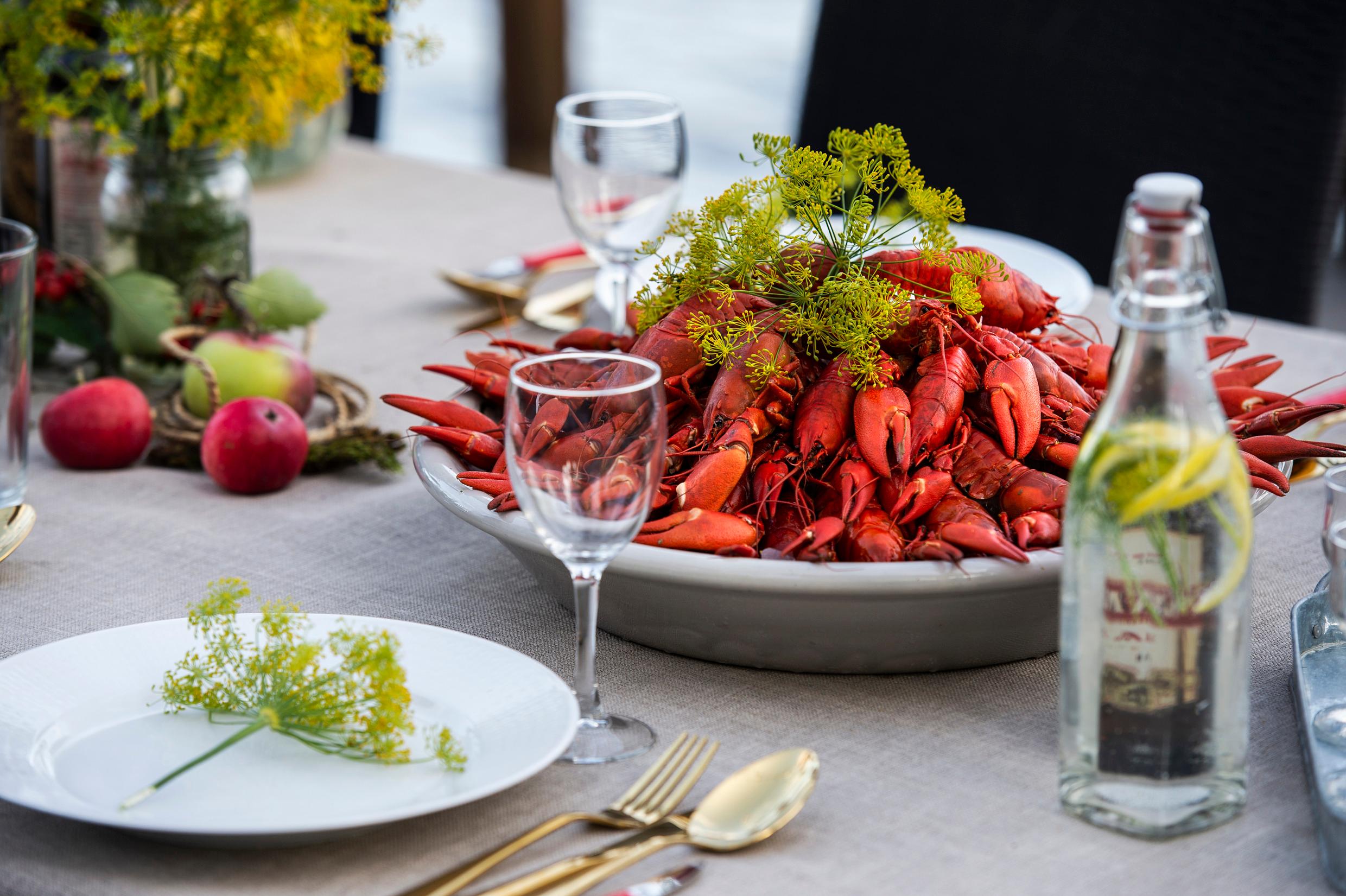 A heap of crayfish in a bowl on a nicely decorated table.