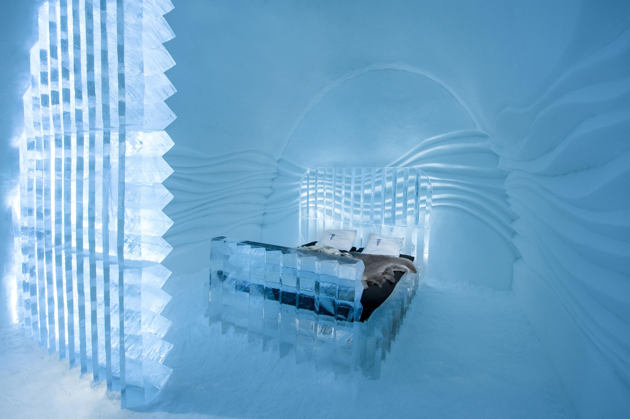 A room with a bed, all made of ice.