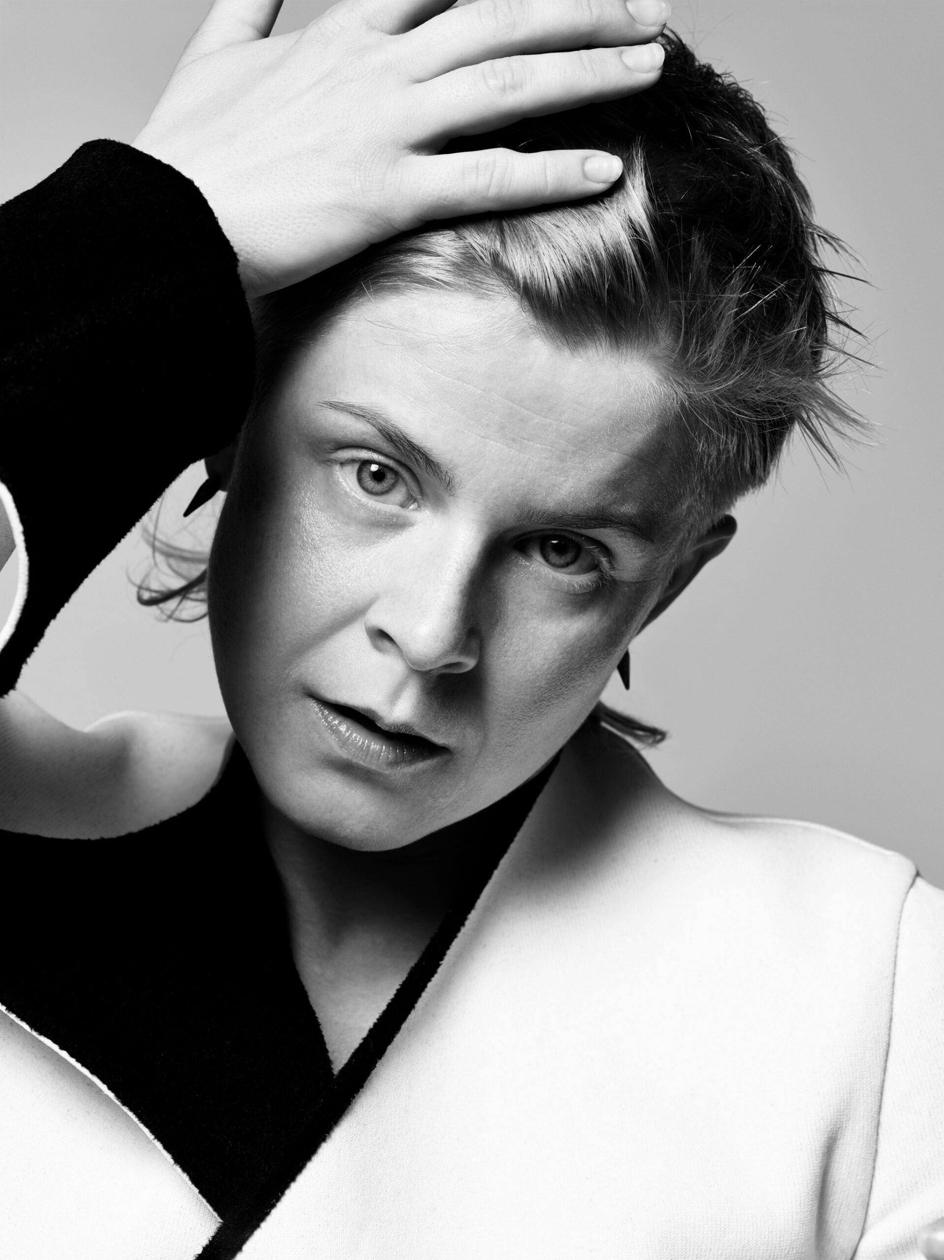 A black-and-white photo of Robyn, holding one hand on her head. Robyn is the pop queen of Swedish music.