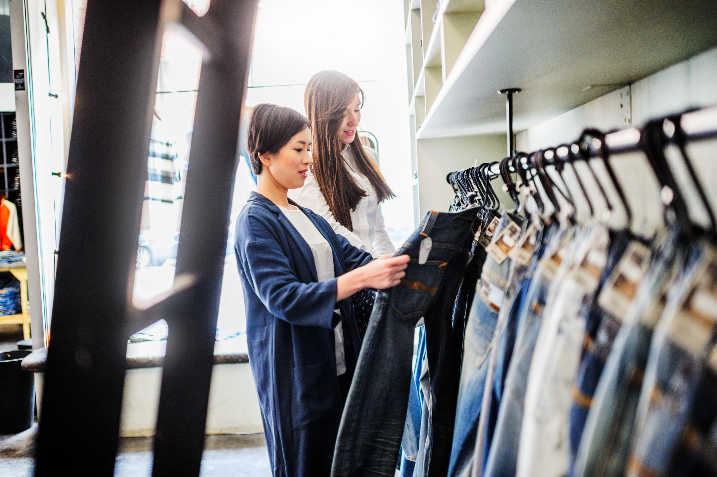 Two women are browsing jeans at the Nudie designer store in central Stockholm.