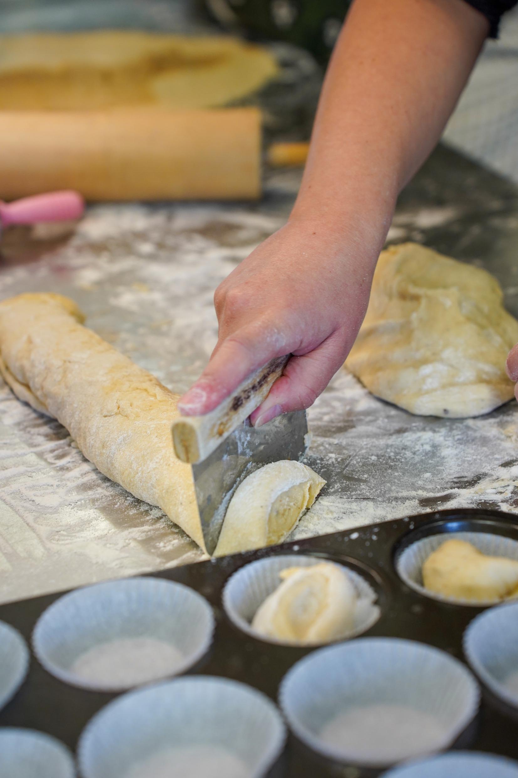 People baking cinnamon buns.