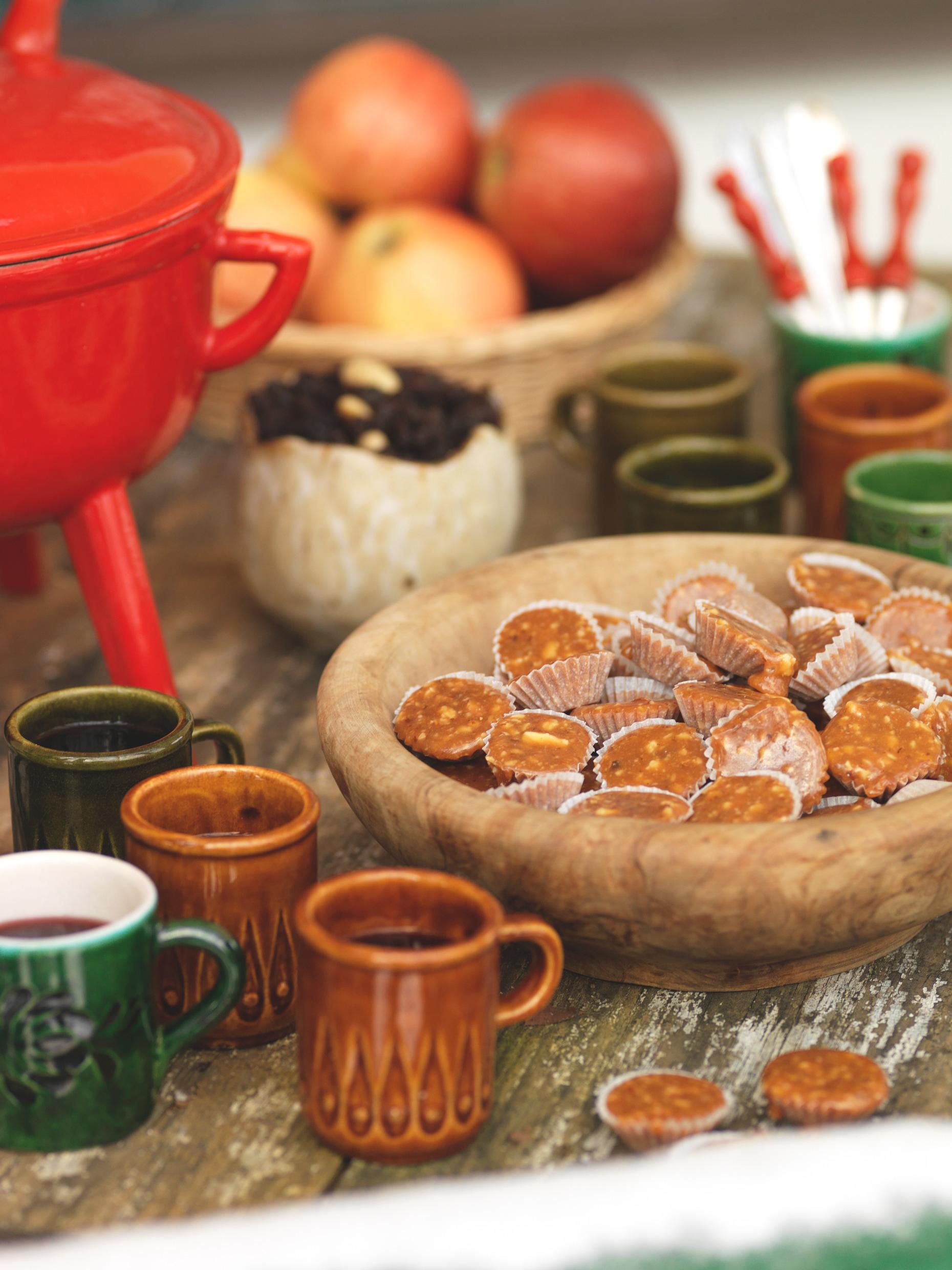 Small cups with mulled wine next to a bowl with 'knäck'.