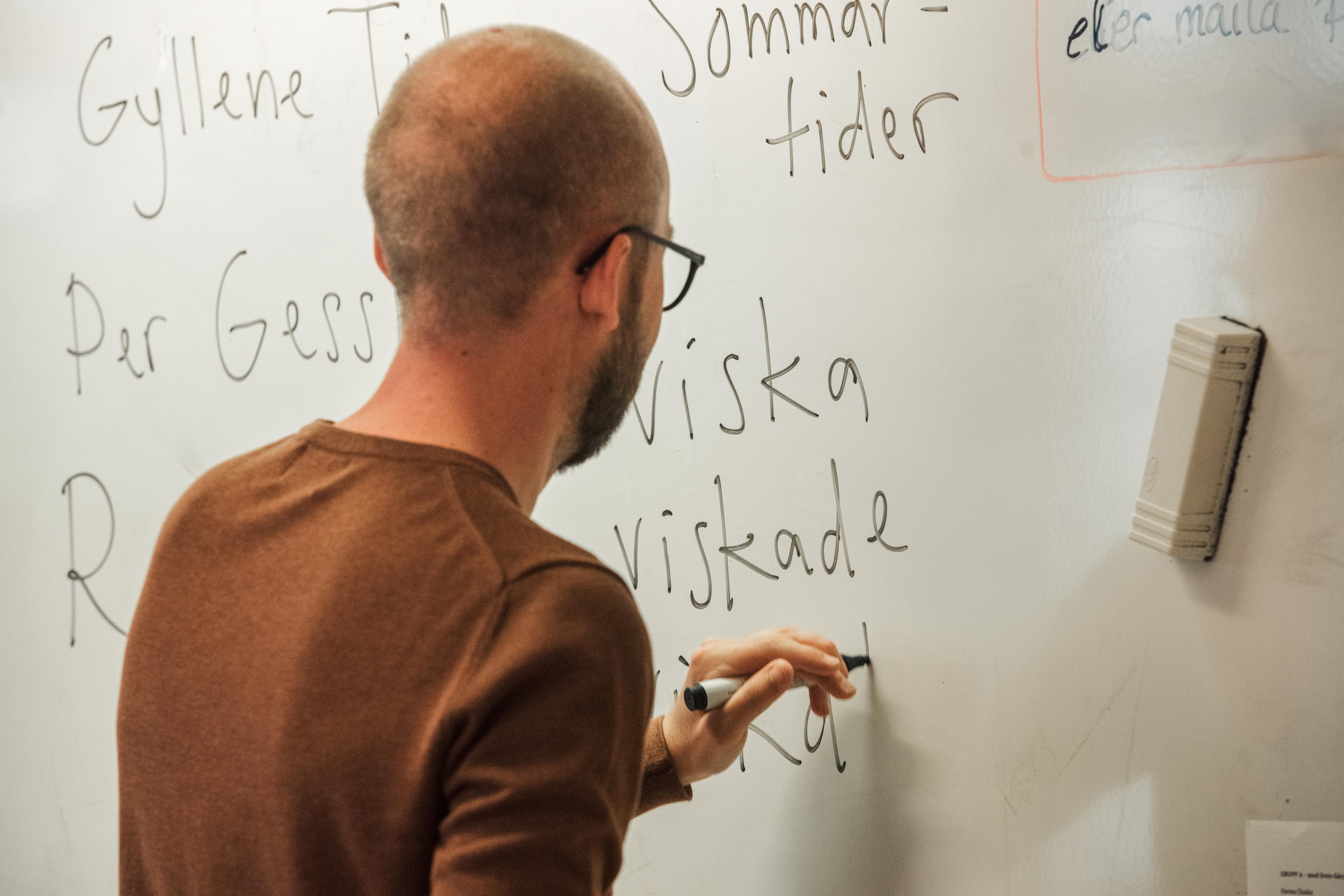 A man writing on a whiteboard.