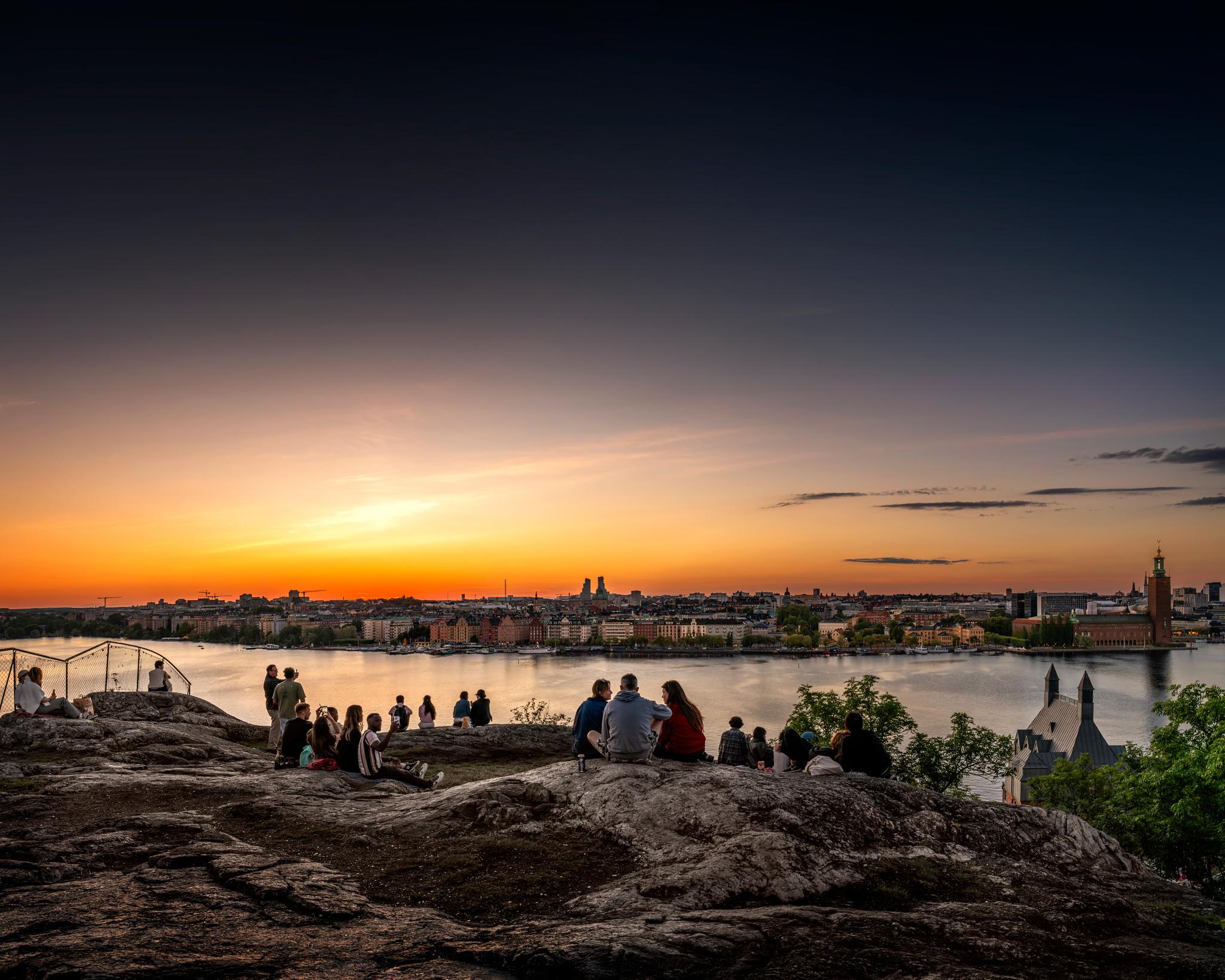 People on a mountain against a sunset backdrop.
