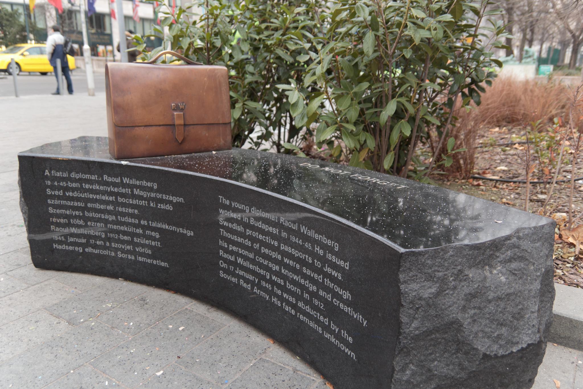 A Raoul Wallenberg monument in Budapest in the shape of a stone bench with a briefcase on.
